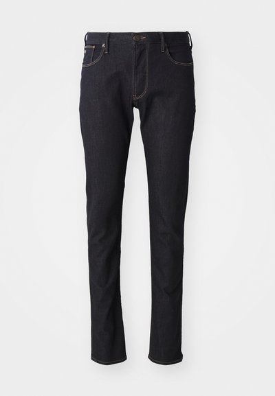 Jean bleu foncé en denim, avec une coupe droite, cinq poches, des coutures contrastantes et une fermeture à bouton classique.