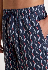 Marine zwemshorts met een vogelpatroon in rood, grijs en wit, voorzien van een elastische tailleband en zijzakken voor extra gemak.