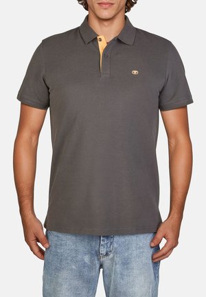 Grijze polo shirt met korte mouwen, heeft een oranje kraag, traditionele knoopsluiting met drie knopen en een klein logo op de linkerkant van de borst.