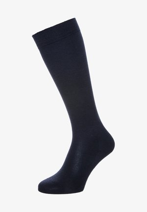Meia de dress navy com uma textura suave, punho canelado e forma tradicional, adequada para vestuário formal e casual.