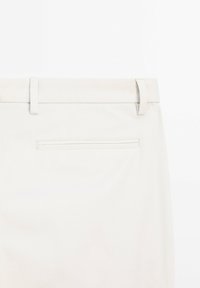Helle beigen Hosen mit gerader Form, gefertigt aus einem glatten Material. Mit einer Gesäßtasche mit Paspel und Gürtelschlaufen.