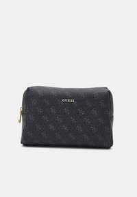 Trousse de maquillage noire avec un motif texturé, ornée d'un logo "GUESS" doré. Fermeture à glissière, forme rectangulaire et matériau lisse.
