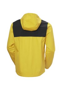 Chaqueta impermeable amarilla con yugo negro, capucha, puños elásticos y un corte holgado. Tejido ligero con textura suave.