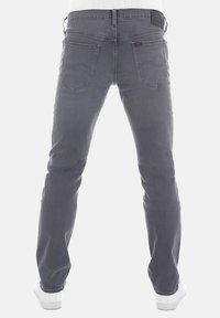 Jeans in denim grigio con taglio dritto, cinque tasche e una finitura texturizzata. La vista posteriore evidenzia gli accenti curvi delle tasche.