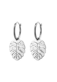 Orecchini a cerchio in argento con pendenti a forma di foglia di monstera perforata, con una finitura liscia e un chiaro contorno delle vene della foglia.