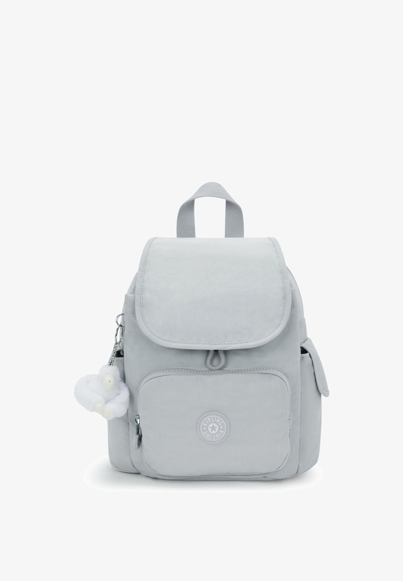 Sac à dos gris avec une fermeture à rabat, une poche avant et une poche latérale. Comprend un porte-clés en peluche et un patch logo sur le devant. Tissu texturé.