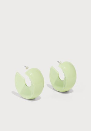 Grüne durchsichtige kreisförmige Ohrringe mit einem geschwungenen, offenen Design und einer glänzenden Oberfläche. Sie verfügen über einen Stecker-Verschluss für sicheren Tragekomfort.