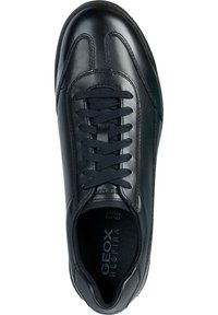 Černé kožené tenisky s kulatou špičkou, polstrovaným límcem a předním šněrováním. Obsahují texturovanou stélku a decentní branding na vnitřní straně.