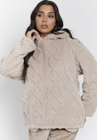 Lichtbeige fleece hoodie met een gestructureerd ruitpatroon, een capuchon en een losse pasvorm. Heeft wijde mouwen en een zachte, pluche afwerking.