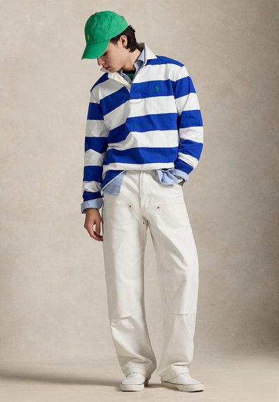 Long-sleeve striped polo shirt in blue and white, paired with white pants and a green cap. Smooth cotton texture with contrasting colors.