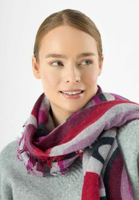 Multicolore sjaal met strepen in tinten van rood, paars en grijs. Gemaakt van zacht materiaal met rafelige randen. Casual gedragen.