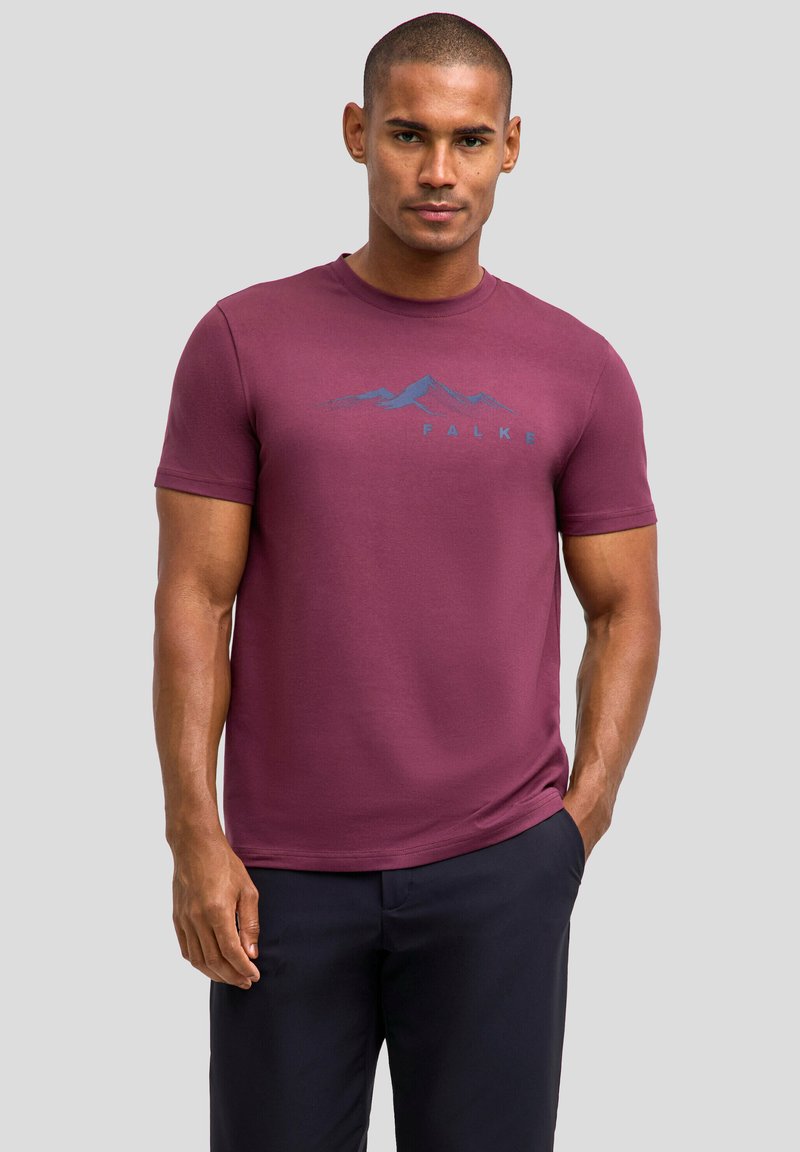 Bordeauxrotes T-Shirt mit kurzen Ärmeln und Rundhalsausschnitt, das ein Bergmotiv und den Schriftzug "FALKE" in Blau zeigt. Hergestellt aus weichem, glattem Baumwollmaterial.