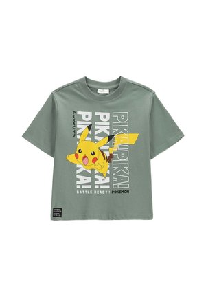 Zielona koszulka z krótkim rękawem z dużą grafiką Pikachu i powtarzającym się tekstem "PIKA PIKA", oraz "BATTLE READY! POKÉMON" na dole.