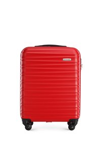 Red hard-shell suitcase with ribbed texture, black wheels, and a top handle. Features a silver logo plate on the front.