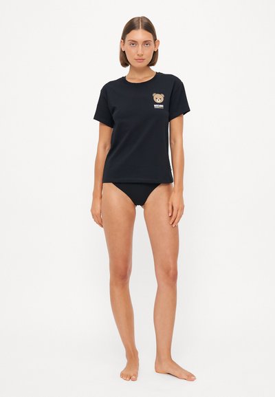 Black cotton t-shirt featuring a bear graphic on the chest. The t-shirt has a crew neck and short sleeves. Worn with black bikini bottoms.