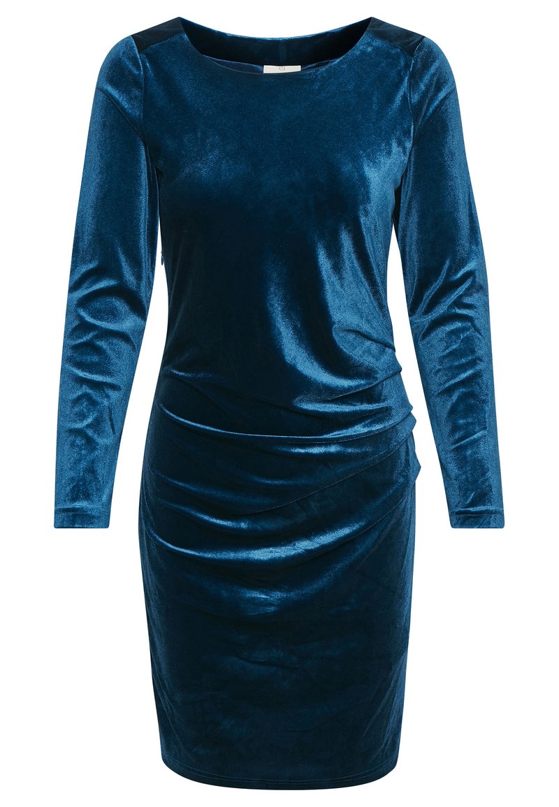 Zöld tónusú bársonydressz hosszú ujjakkal, kerek nyakkivágással és oldalsó redőzéssel a karcsú sziluettért. Sima textúra, fényes felülettel.