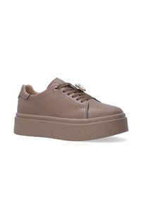 Braune Kunstleder-Sneaker mit runder Zehenpartie, Schnürung an der Vorderseite, dickem strukturiertem Sohlenprofil und dekorativem metallischem Akzent auf der Zunge.