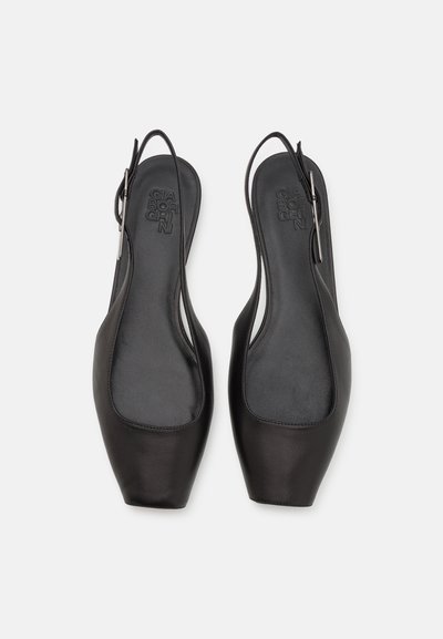 Svarta slingback-skor med slät läder, spetsiga tår, öppen häl och en subtil varumärkesprägel på innersulorna.