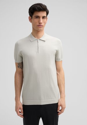 Lichtgrijs polo shirt met korte mouwen en een ritskraag, gemaakt van textuurstof. Heeft een rechte snit en geribbelde zoom. Geen patronen of accenten.