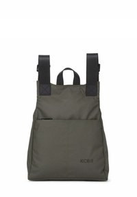 Mochila de tela verde con correas negras ajustables, asa superior y un bolsillo frontal con cremallera. Presenta un diseño minimalista y detalle de logo.