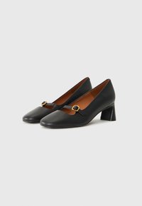 Black leather heels with a square toe, featuring a small strap with a gold buckle and a block heel. Interior lining is brown.