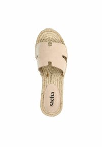 Beige instapsandaal met een zachte leren bovenkant met twee uitgesneden vormen. Gevlochten jute zool voegt textuur toe, met een zichtbaar merklogo.