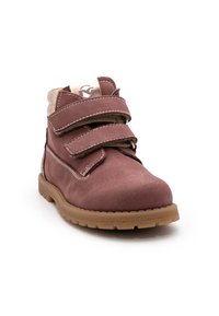 Braune Wildleder-Ankle-Boots mit zwei Klettverschlüssen, kontrastierender Naht und einer hellen Gummisohle, ausgestattet mit einem gepolsterten Knöchel für zusätzlichen Komfort.