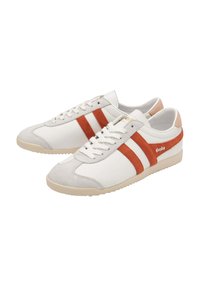 Sneakers bianchi in tela con strisce in suede arancioni, punta in suede grigia e suola in gomma beige. Presentano una chiusura con lacci e un colletto imbottito.
