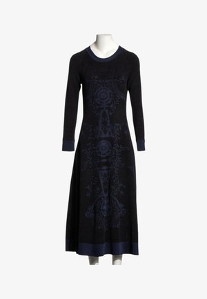 Longue robe noire avec des motifs floraux complexes bleu foncé, col rond, manches longues, et poignets et ourlet bleu foncé sur un mannequin blanc.