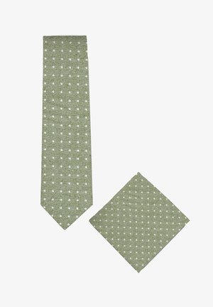 Grüne Krawatte und passendes Einstecktuch mit kleinen weißen Punkten und diagonaler Gewebetextur auf weißem Hintergrund.