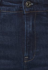 Mörkblå denimjeans med en slät textur, med knappstängning fram, kontrasterande guldtråd och rak passform.