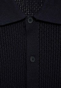 Cardigan lavorato a maglia di un blu navy con colletto, chiusura con bottoni e un intricato motivo a rete aperta. Texture morbida in tutto il capo.