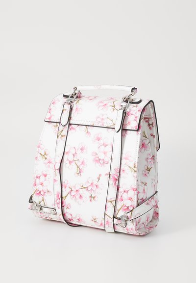 White backpack featuring a floral pattern with pink flowers, silver hardware, and a structured design. Includes adjustable straps and a top handle.