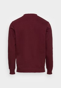 Bordeauxfarbenes Sweatshirt, weicher Stoff, runder Ausschnitt, lange Ärmel, gerippte Bündchen und Saum, einfarbig ohne sichtbare Logos oder Muster.