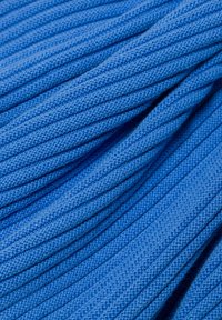 Blaue Baumwollsenkel, die in überlappenden Spiralen angeordnet sind, mit einer strukturierten Oberfläche und einem feinen Gewebe-Muster.