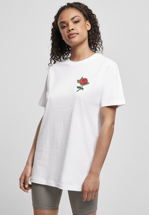 White cotton t-shirt featuring a red rose embroidery on the left chest. Short sleeves and relaxed fit. Smooth texture.