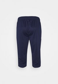 Marineblå atletiske capri-bukser lavet af letvægtsstof, med elastisk talje og sidelommer for funktionalitet. Glat tekstur.