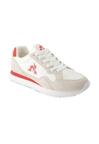 Sneakers atletiche bianchi e beige con accenti rossi. Realizzati in pelle e suede, dotati di una suola texturizzata e lacci. Logo sul lato.