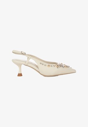 Decolleté slingback color crema con punta affusolata e piccolo tacco kitten, decorata con borchie dorate e argentate e punte sulla parte superiore.