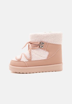 Botte d'hiver rose clair avec doublure en polaire, semelle épaisse, lacets à l'avant et œillets métalliques pour une fixation sécurisée.