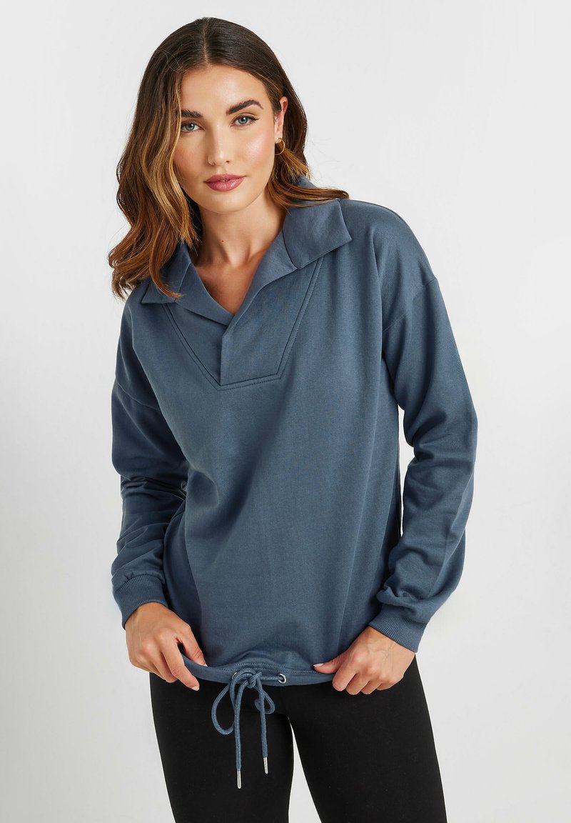 Pullover in cotone blu con colletto, maniche lunghe e orlo con cordino. Presenta un'apertura a V sul petto e polsini a coste.