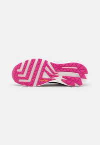Suela de zapato con una base blanca y una banda de rodadura de goma rosa, decorada con formas geométricas y un logo de Goodyear en amarillo.