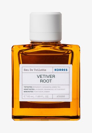 Bouteille en verre rectangulaire claire contenant un liquide orange, avec un capuchon blanc et une étiquette détaillant les notes de tête, de cœur et de fond du parfum Vetiver Root.