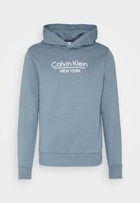 Felpa con cappuccio in tessuto azzurro chiaro con polsini e orlo a coste. Presenta il logo bianco "Calvin Klein NEW YORK" sul davanti.