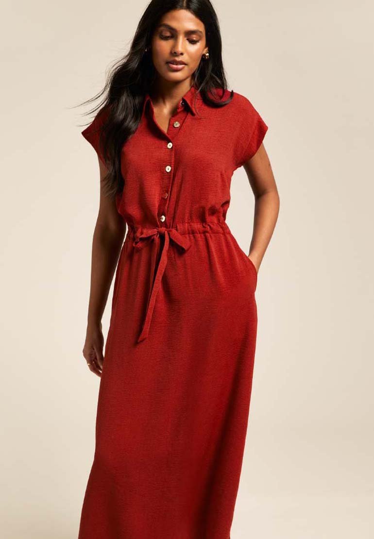 Vestido rojo hasta la rodilla con mangas cortas, cierre delantero de botones y cinturón en la cintura. Hecho de una tela texturizada con un ajuste relajado y dos bolsillos laterales.