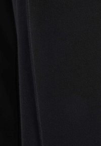 Tejido negro con un acabado suave y texturizado, que presenta un patrón acanalado. El material parece suave y elástico, adecuado para un uso casual.