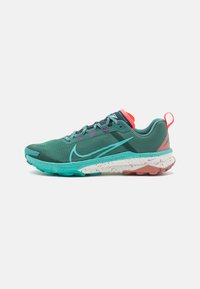 Grüne Laufschuhe mit Mesh-Obermaterial, türkisfarbenen und korallenfarbenen Akzenten, gepunkteter Zwischensohle und strukturierter Gummisohle.