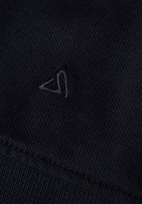 Zwarte stof met een gestikt driehoekig logo. De stof is glad met een fijne brei textuur en zichtbare stitching langs de randen.