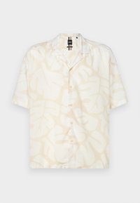 Camicia a maniche corte con bottoni, con motivo di foglie tropicali beige su sfondo bianco, dalla vestibilità rilassata e colletto da campeggio.