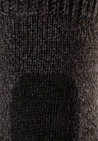 Tejido de punto marrón oscuro con una textura ligeramente difusa, que presenta un patrón acanalado en la parte superior y un cosido suave y uniforme en todo.